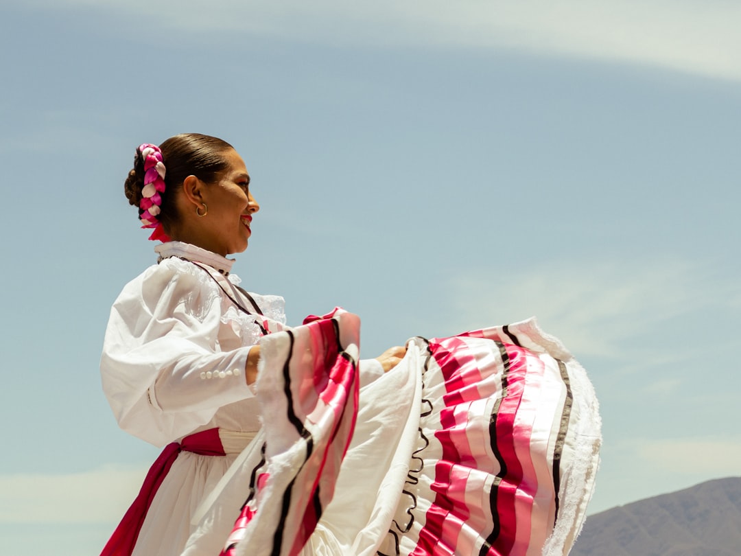 A conceptual image blending elements of Mexican and Indian wellness traditions, such as a hand holding a marigold next to a yoga mat.