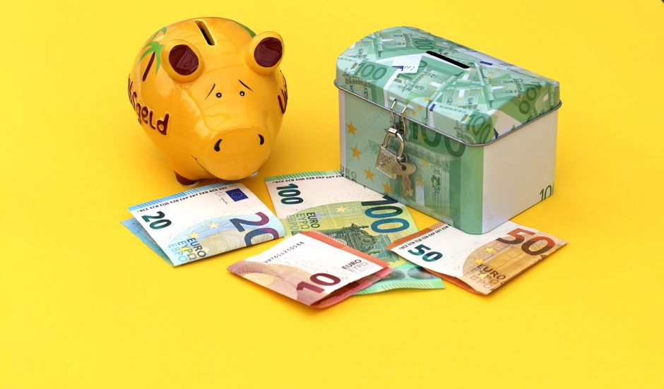 Modern piggy bank sits next to a set of house keys on a clean, bright tabletop, symbolizing the concept of saving money on...
