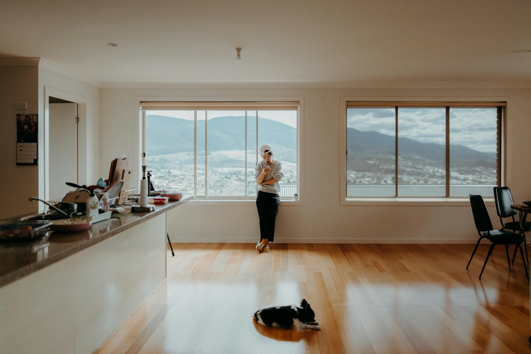 A person sits at a bright, modern desk carefully reviewing a real estate contract with a pen, representing smart financial decisions and negotiation.